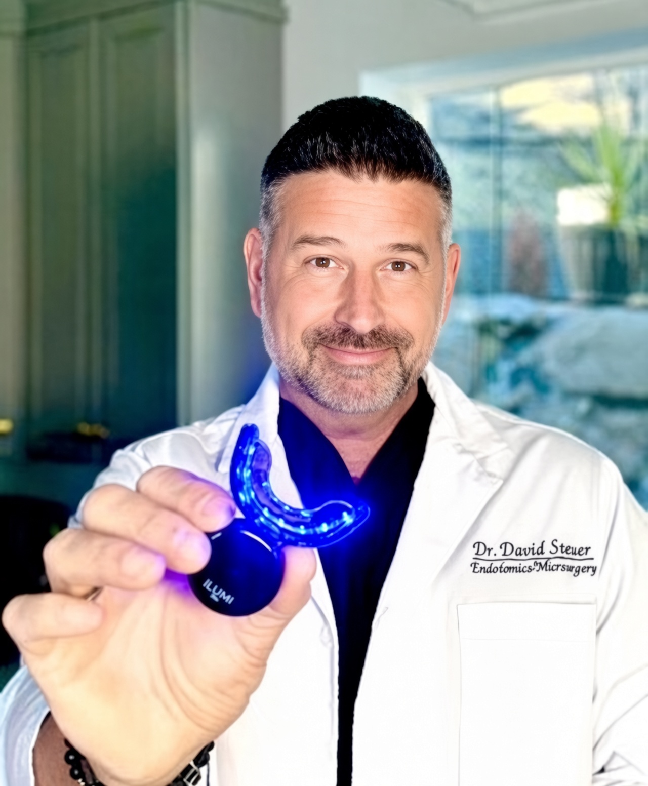 Dr. Dave Steuer, Harvard-trained endodontist, holding the illuminated ILUMI LED whitening mouthpiece