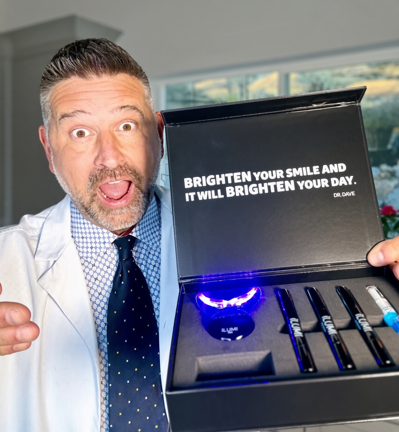 Dr. Dave Steuer presenting the open ILUMI LED Teeth Whitening Kit with the LED tray lit inside the box